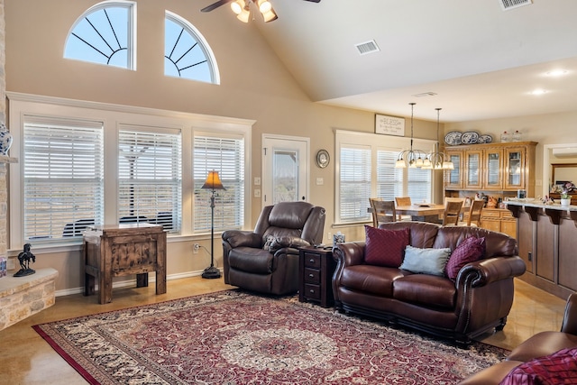 living room with ceiling fan with notable chandelier and vaulted ceiling