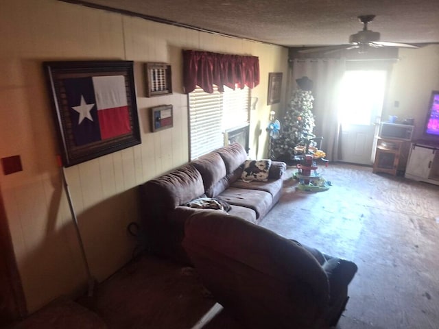 living room with ceiling fan and a textured ceiling