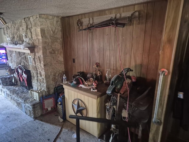 misc room with a textured ceiling and wooden walls