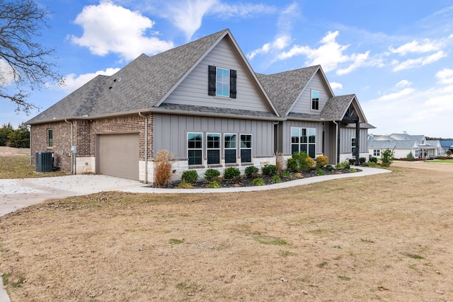 craftsman-style home featuring central air condition unit, a front lawn, and a garage