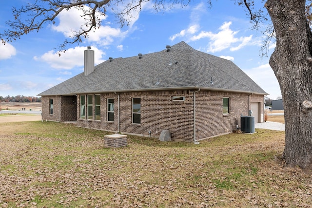 175 Quail Ridge Ct, Decatur, TX 76234 - back of property with a shingled roof, a chimney, central AC, brick siding, and a lawn