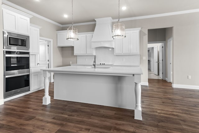 kitchen with stainless steel appliances, a kitchen island with sink, and white cabinets