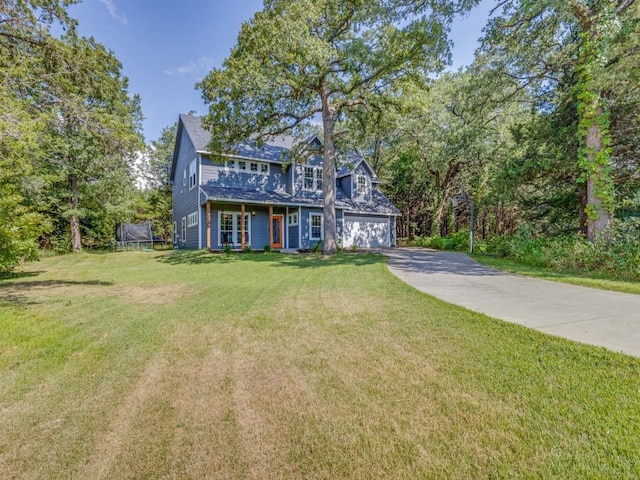 view of front of property featuring a garage, a trampoline, and a front lawn