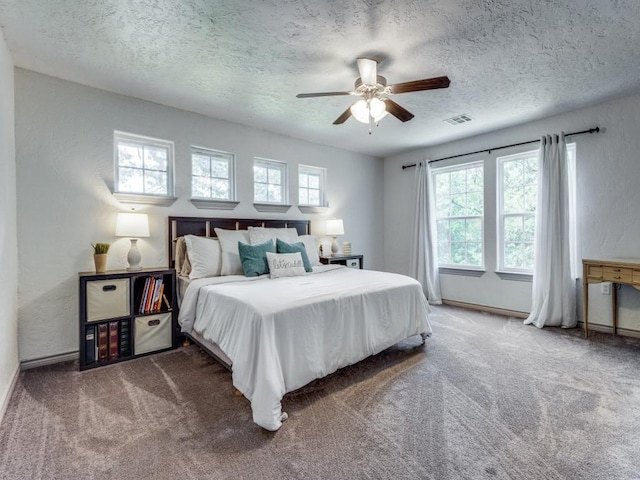 carpeted bedroom with ceiling fan and a textured ceiling