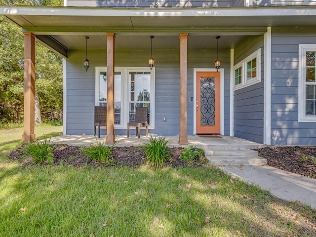 property entrance featuring a porch and a yard