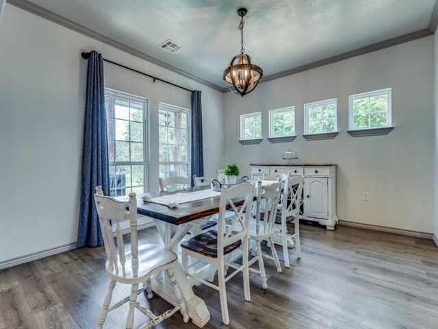 dining area with a chandelier, crown molding, and light hardwood / wood-style floors