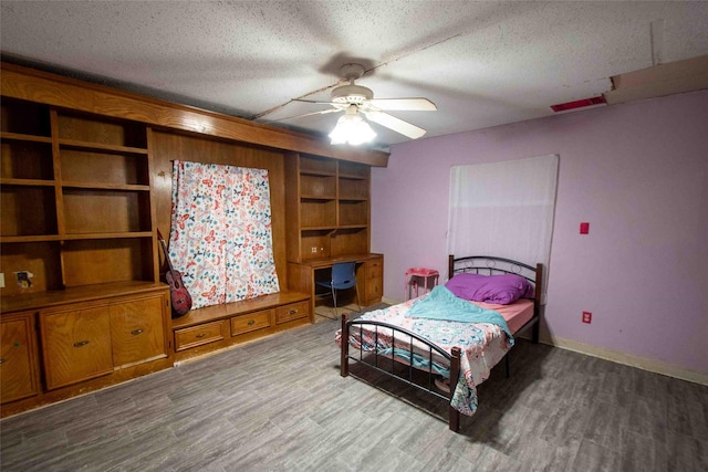 bedroom with a textured ceiling, hardwood / wood-style flooring, and ceiling fan