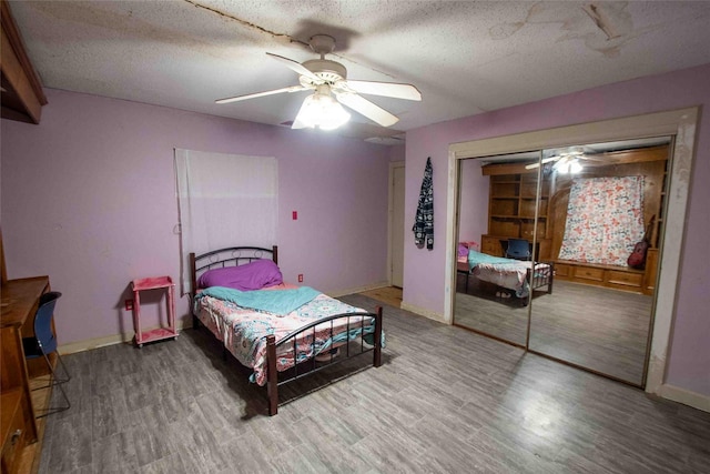 bedroom featuring hardwood / wood-style floors, a closet, a textured ceiling, and ceiling fan