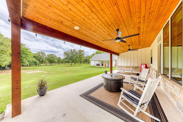 view of patio with ceiling fan and an outdoor fire pit