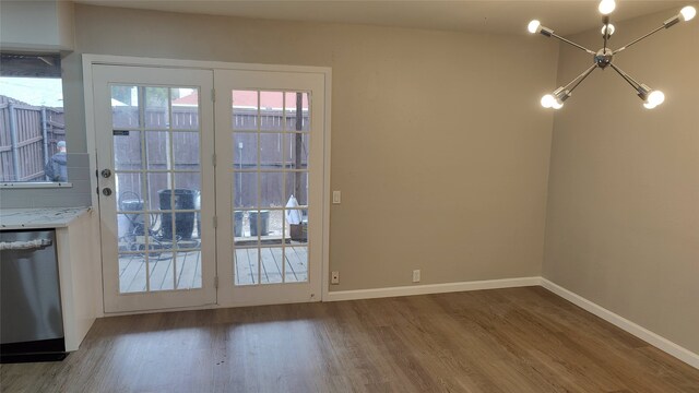 doorway to outside with hardwood / wood-style floors and a chandelier