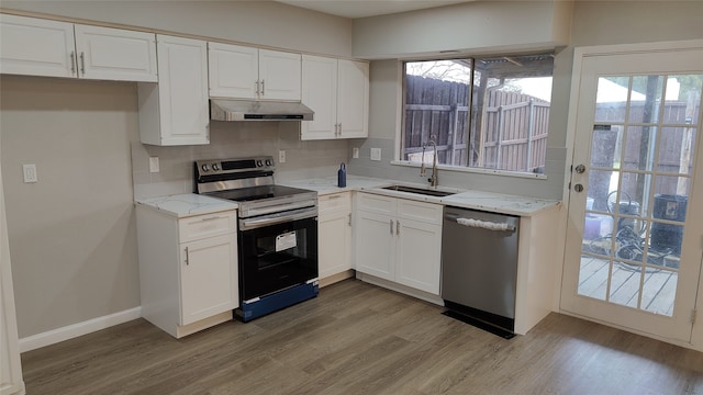 kitchen featuring sink, tasteful backsplash, light hardwood / wood-style floors, white cabinetry, and stainless steel appliances