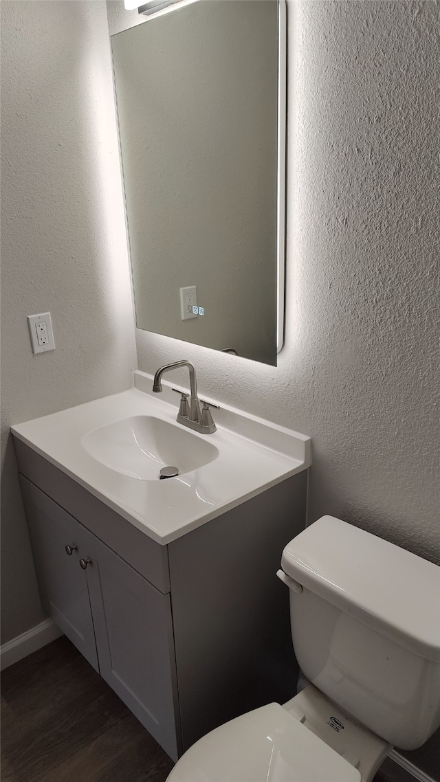 bathroom with vanity, toilet, and wood-type flooring