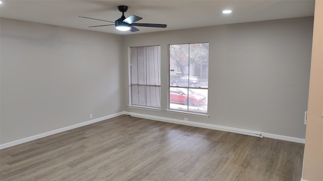 spare room with ceiling fan and light wood-type flooring