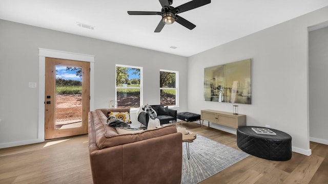 living room with ceiling fan and light hardwood / wood-style flooring