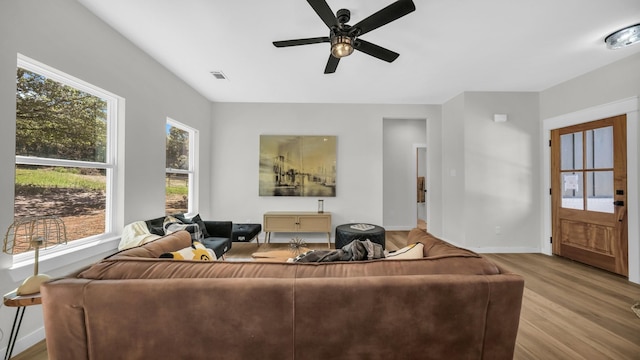 living room with light hardwood / wood-style flooring and ceiling fan