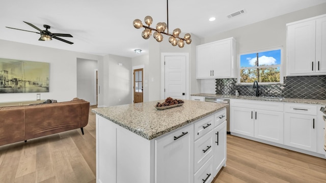 kitchen featuring white cabinetry, a center island, and sink