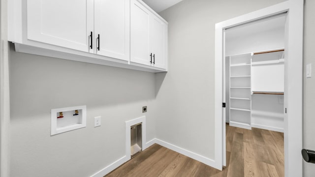 washroom featuring cabinets, washer hookup, light hardwood / wood-style flooring, and hookup for an electric dryer