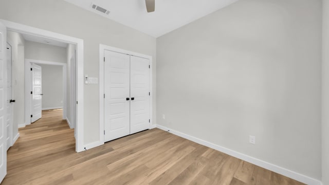 unfurnished bedroom with ceiling fan, a closet, and light hardwood / wood-style floors