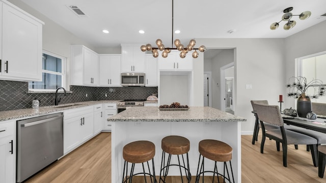 kitchen featuring white cabinets, stainless steel appliances, and a kitchen island