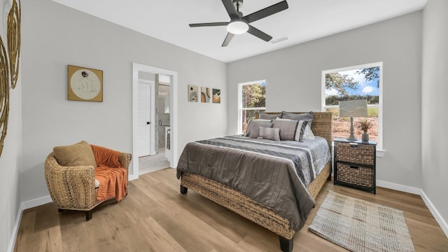 bedroom featuring light hardwood / wood-style floors, ensuite bath, and ceiling fan