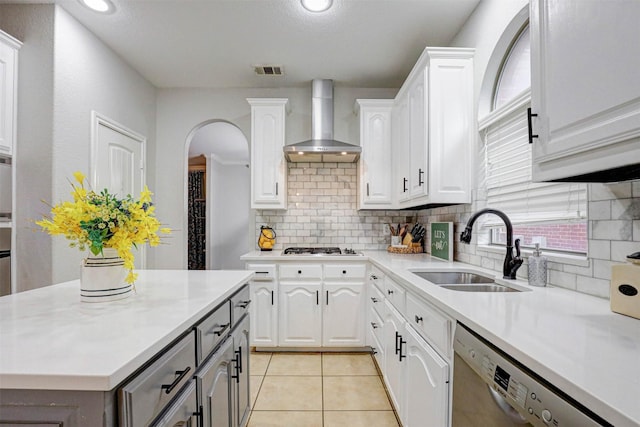 kitchen featuring white cabinets, wall chimney exhaust hood, stainless steel appliances, and tasteful backsplash