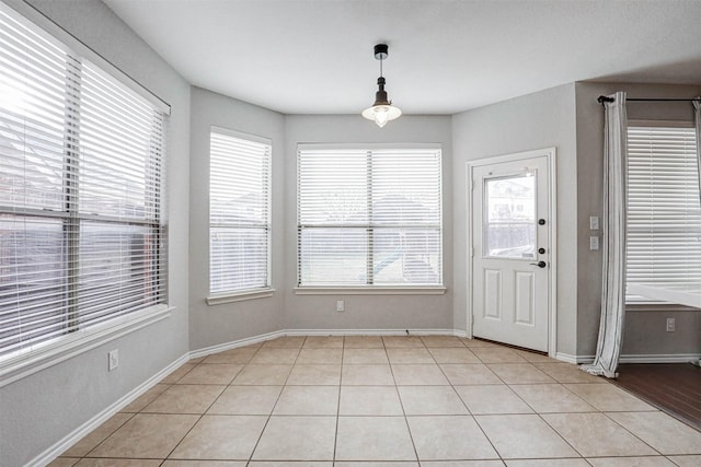 unfurnished dining area featuring light tile patterned floors and a healthy amount of sunlight