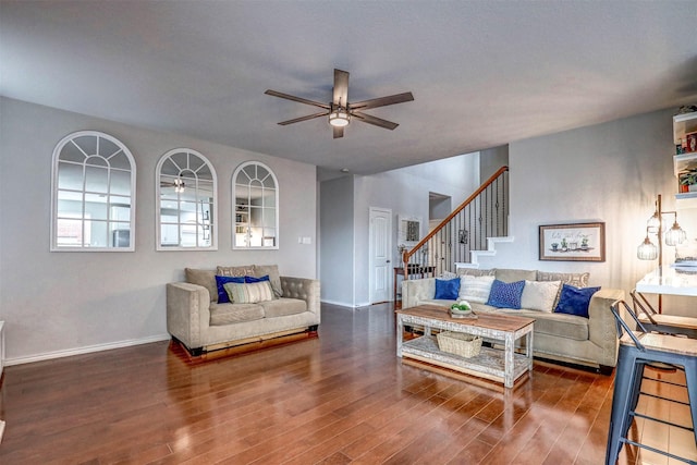 living room with ceiling fan and dark wood-type flooring