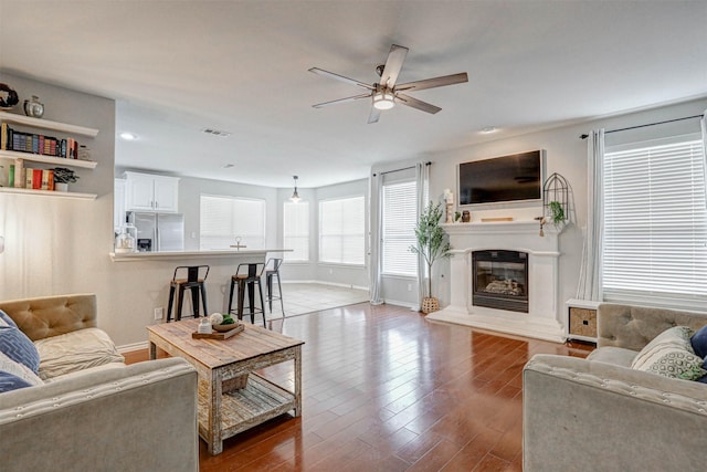 living room featuring a wealth of natural light, ceiling fan, and wood-type flooring