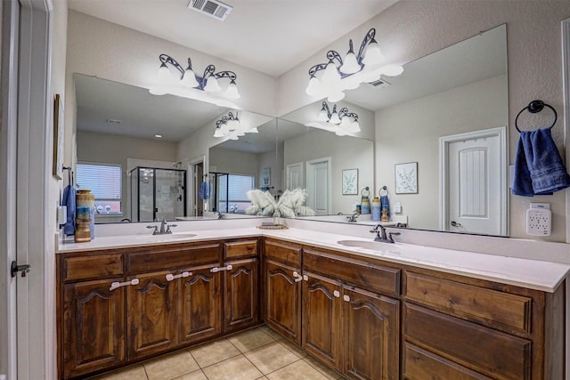 bathroom with tile patterned flooring, vanity, and walk in shower