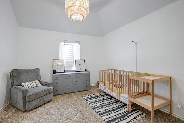 bedroom featuring light carpet, vaulted ceiling, and a nursery area