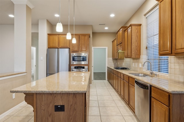 kitchen featuring light stone counters, sink, a kitchen island, and appliances with stainless steel finishes