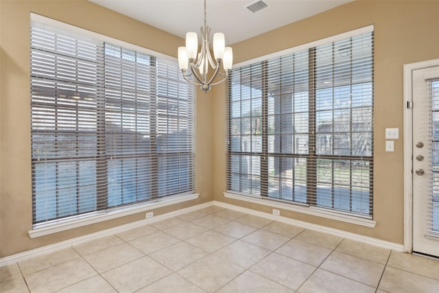 unfurnished dining area with tile patterned flooring and an inviting chandelier