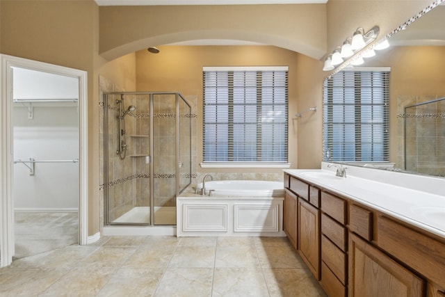 bathroom featuring vanity, plus walk in shower, and tile patterned flooring