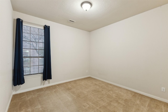 carpeted spare room featuring a textured ceiling