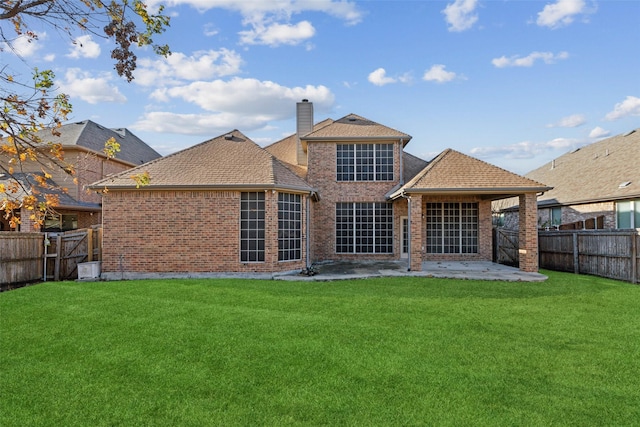 rear view of property with a yard and a patio area