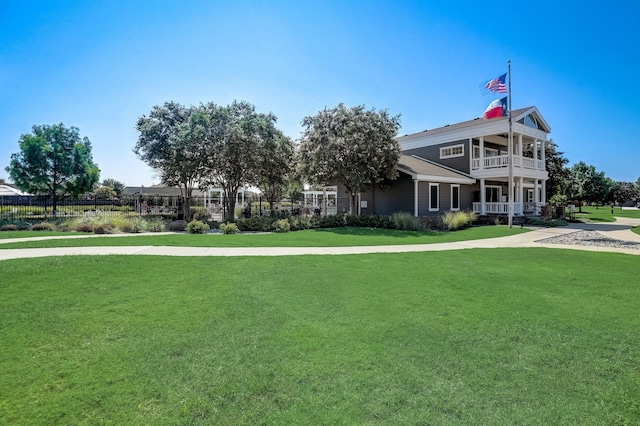 view of front facade with a balcony and a front lawn