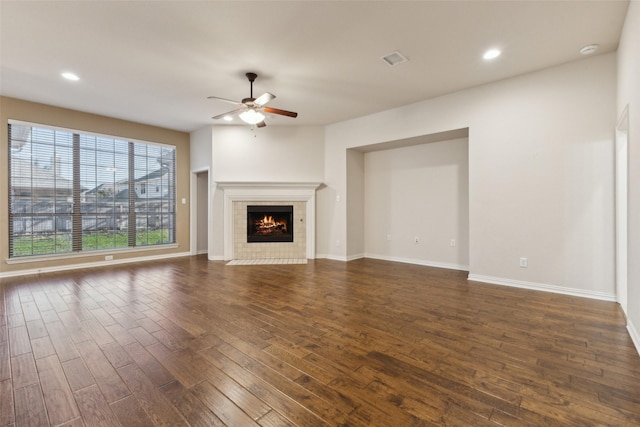 unfurnished living room with ceiling fan, a fireplace, and dark hardwood / wood-style floors