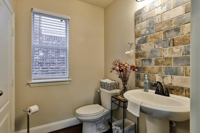 bathroom featuring wood-type flooring, toilet, and sink