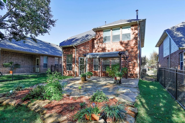 rear view of house featuring a yard and a patio