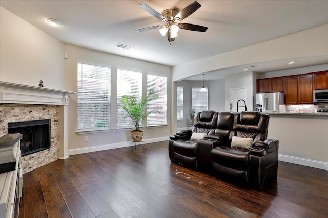 living room with dark hardwood / wood-style flooring, a fireplace, and ceiling fan