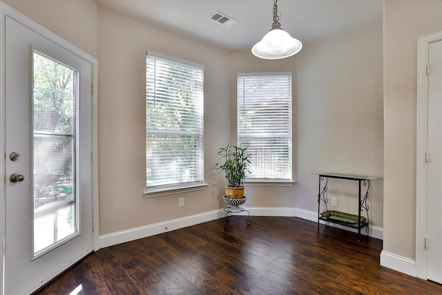 unfurnished dining area featuring plenty of natural light and dark hardwood / wood-style floors