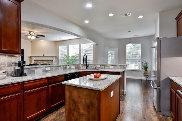 kitchen featuring decorative backsplash, sink, pendant lighting, a kitchen island, and stainless steel refrigerator