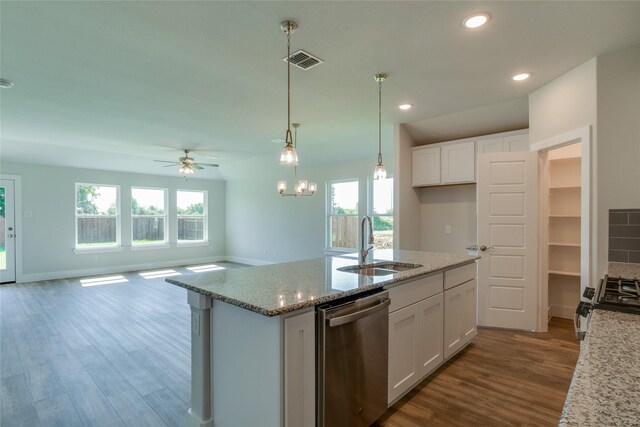 kitchen featuring appliances with stainless steel finishes, light stone counters, sink, a center island with sink, and white cabinetry