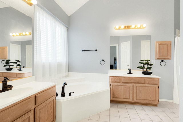 bathroom with tile patterned floors, vanity, a tub to relax in, and vaulted ceiling