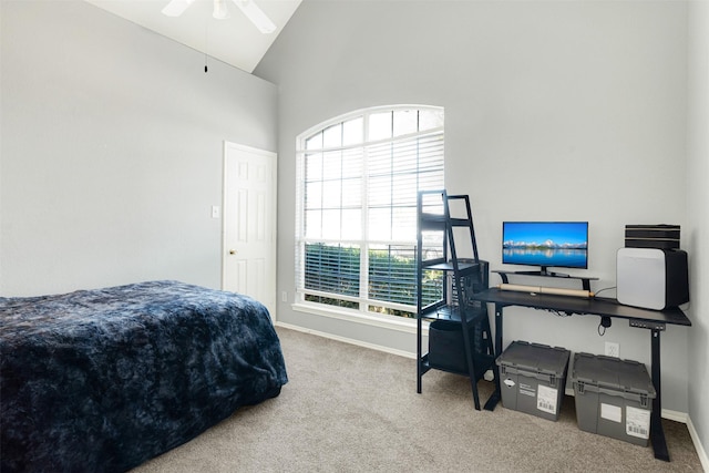 carpeted bedroom with ceiling fan and high vaulted ceiling