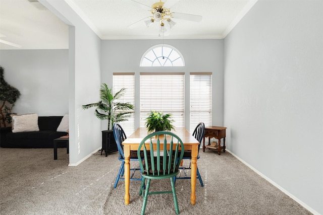 carpeted dining area with ceiling fan and crown molding