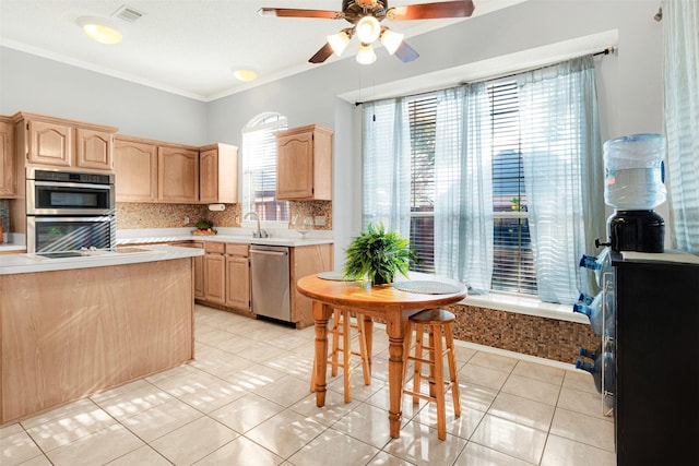 kitchen featuring decorative backsplash, appliances with stainless steel finishes, light brown cabinetry, and light tile patterned flooring