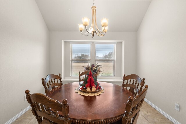 tiled dining space featuring vaulted ceiling and an inviting chandelier