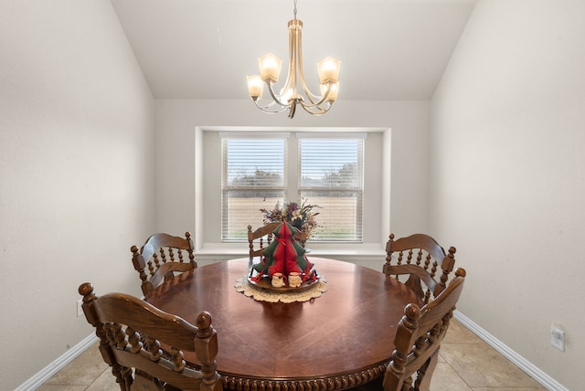 tiled dining room featuring an inviting chandelier and vaulted ceiling