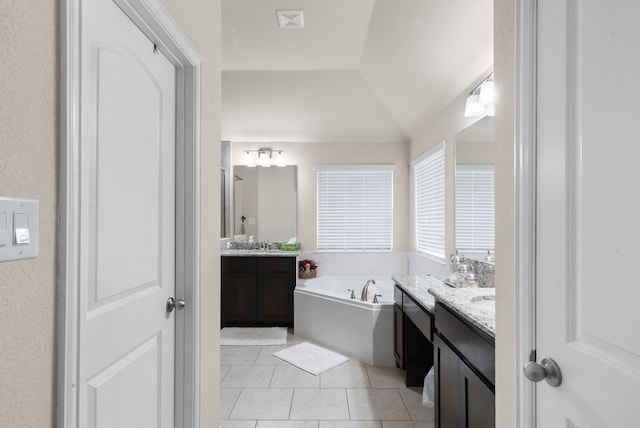 bathroom with vanity, a bathtub, tile patterned floors, and lofted ceiling